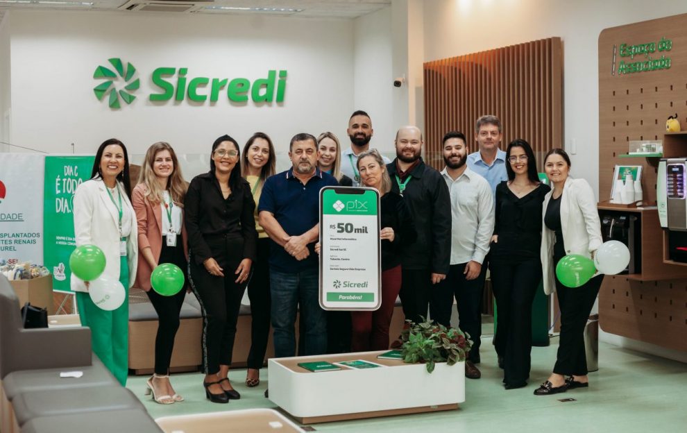 equipe da agencia sicredi tubarao centro com a associada premiada divulgacao sicredi