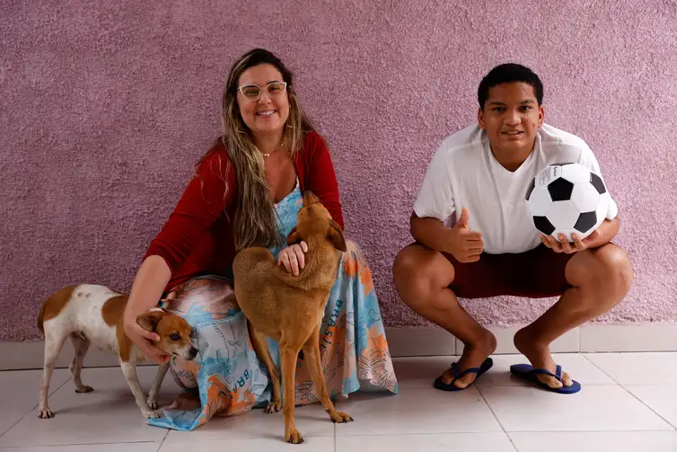 Rio de Janeiro (RJ), 25/10/2024 - Bruna Campos e seu filho Thalyson Barbosa, adotado aos 13 anos, em sua casa em Campo Grande, zona oeste da cidade. Foto: Tânia Rêgo/Agência Brasil